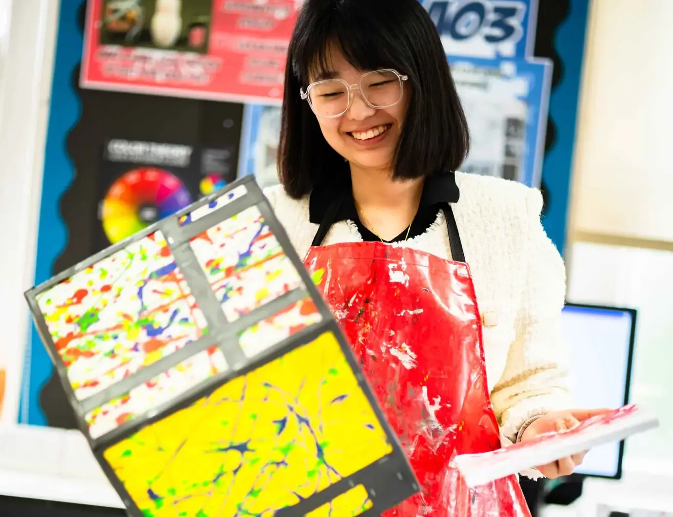 Student holding up painting