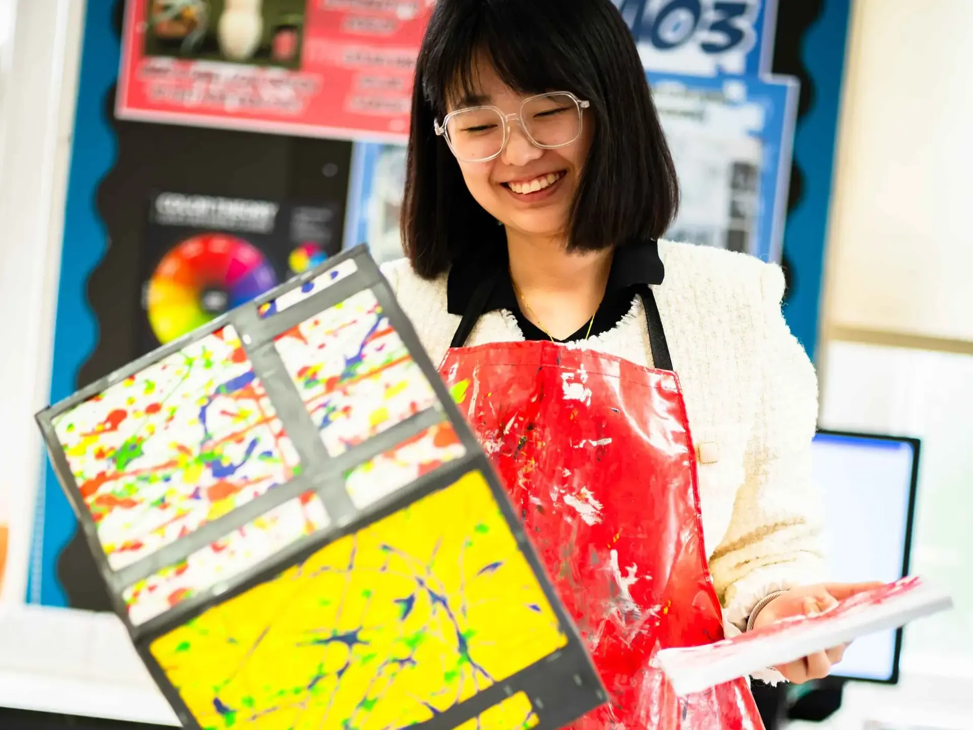 Student holding up painting