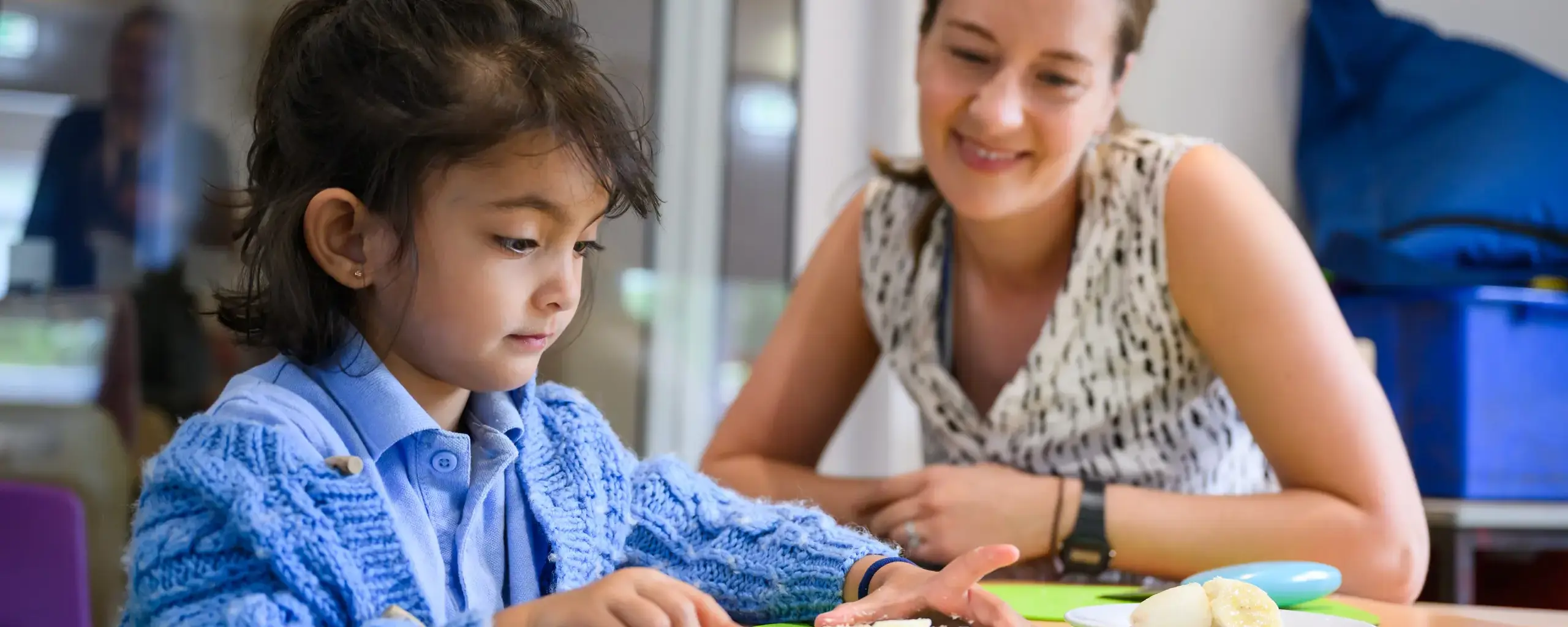 Student and teacher doing arts at table