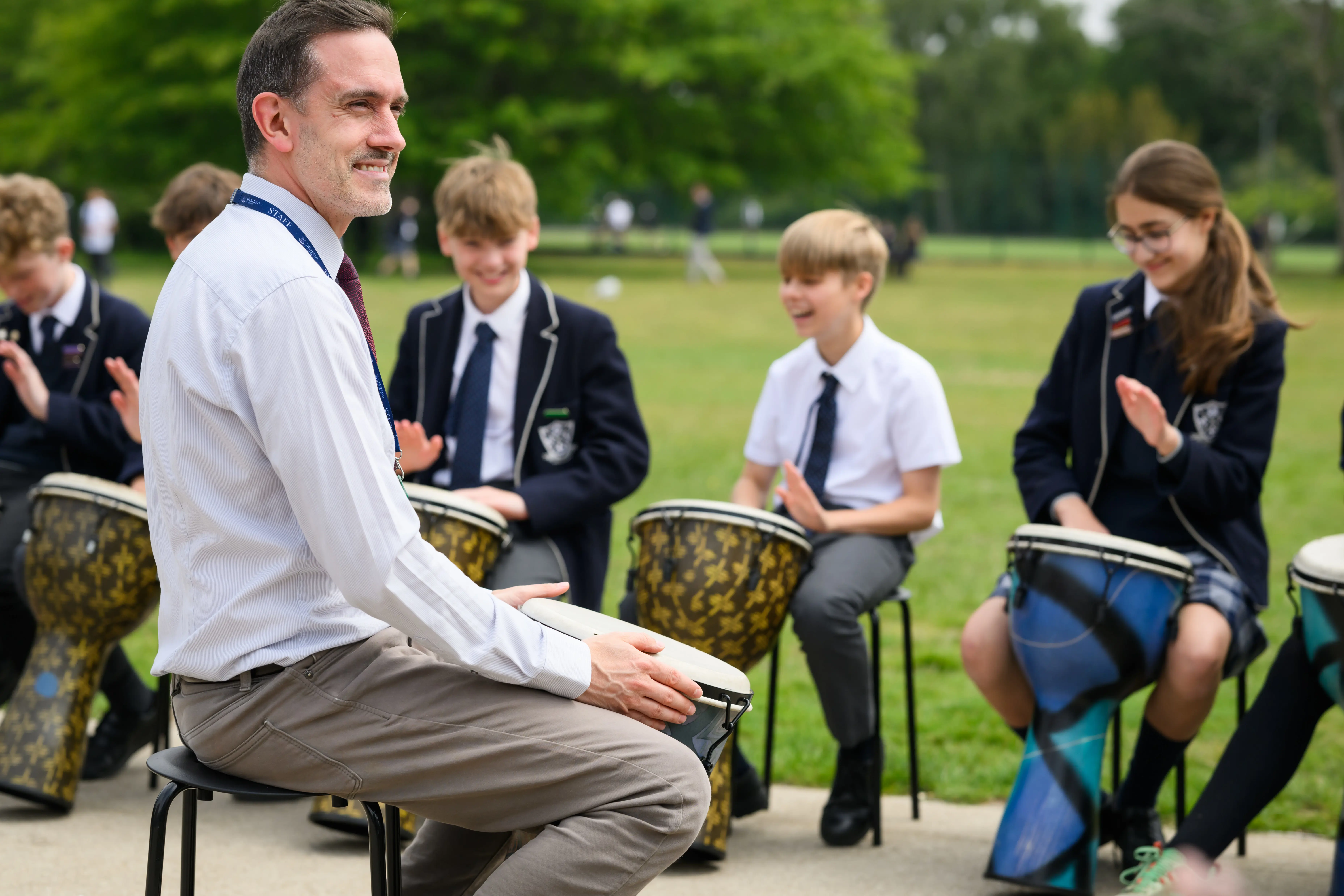 Students playing bongos outdoors