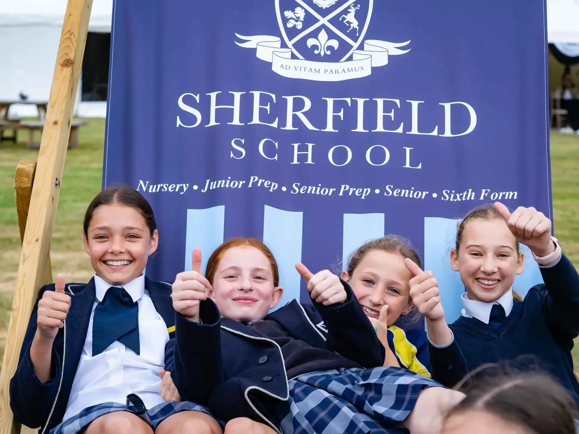 Four students lounging in oversized beach chair