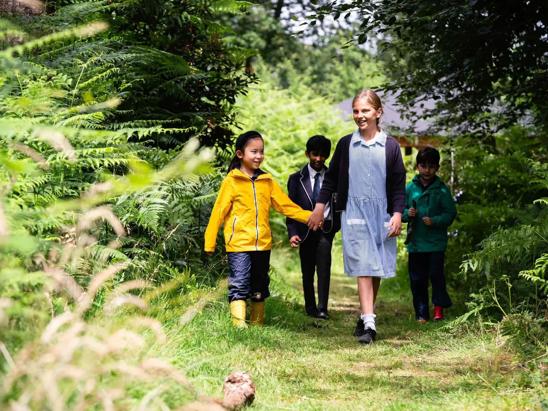 Students walking through copse hand in hand