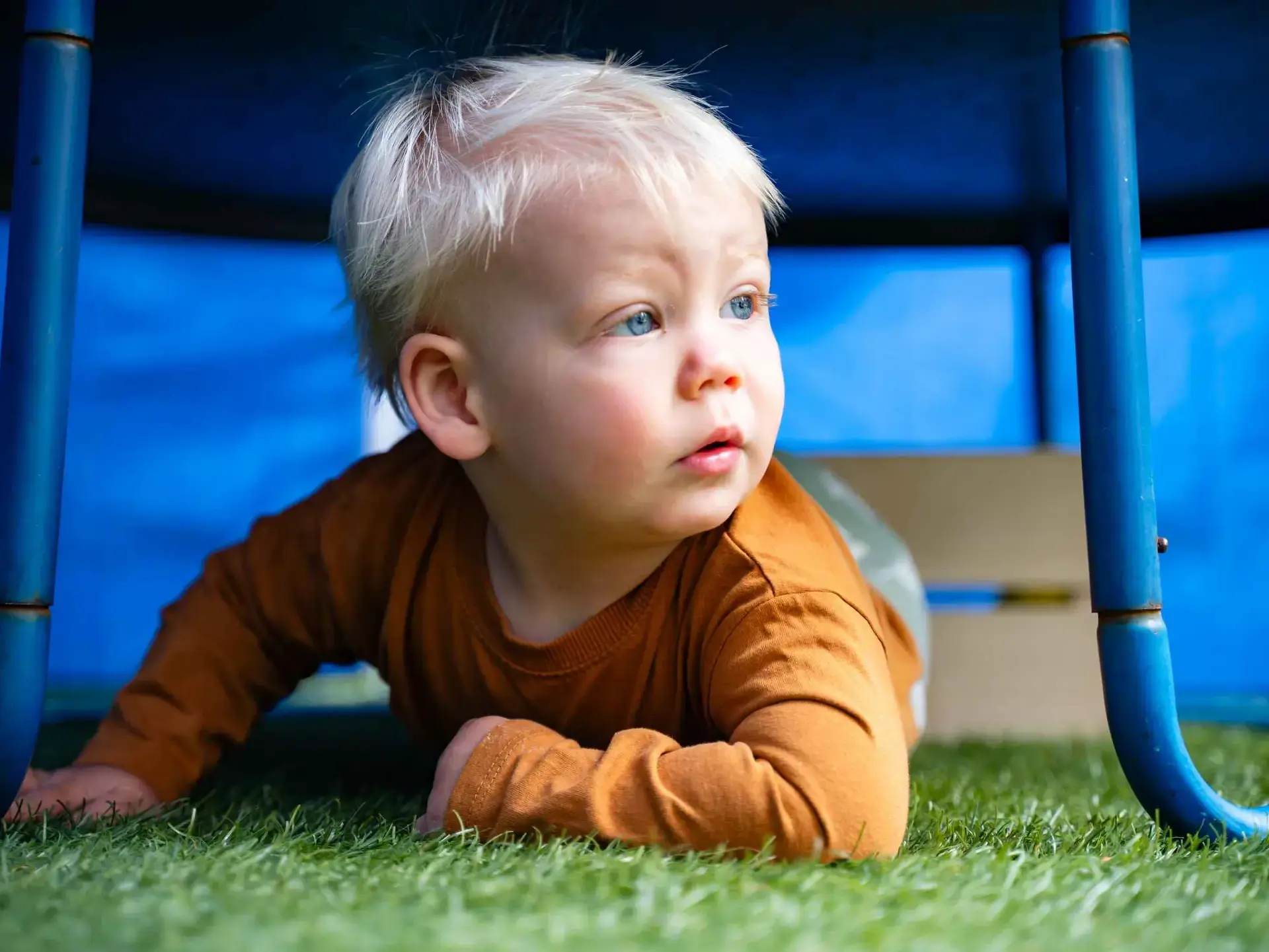 Young child crawling on astroturf