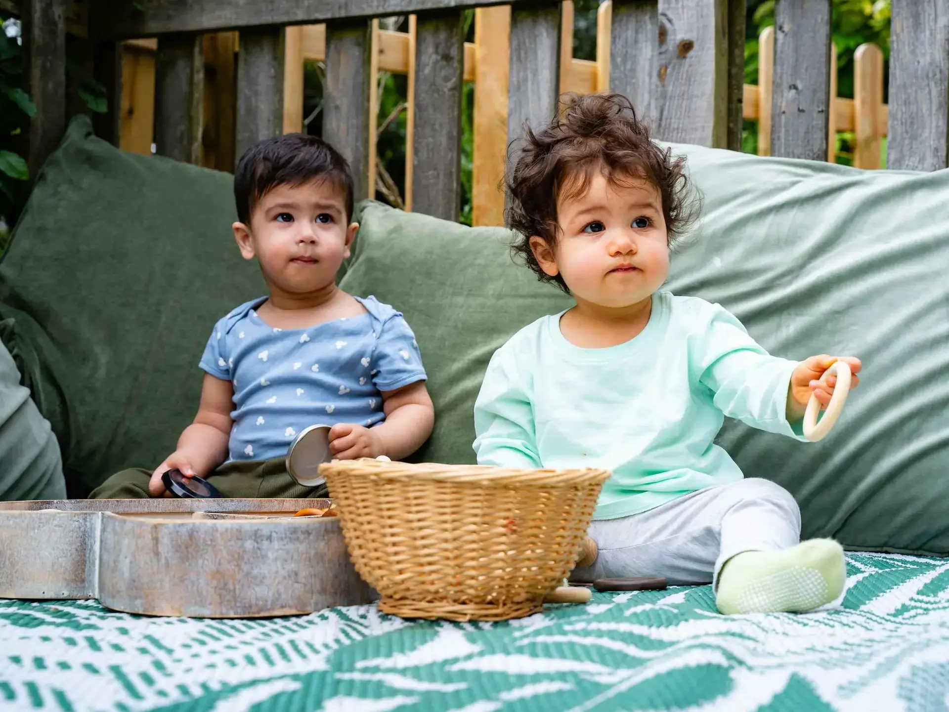 Two children sitting on outdoor furniture
