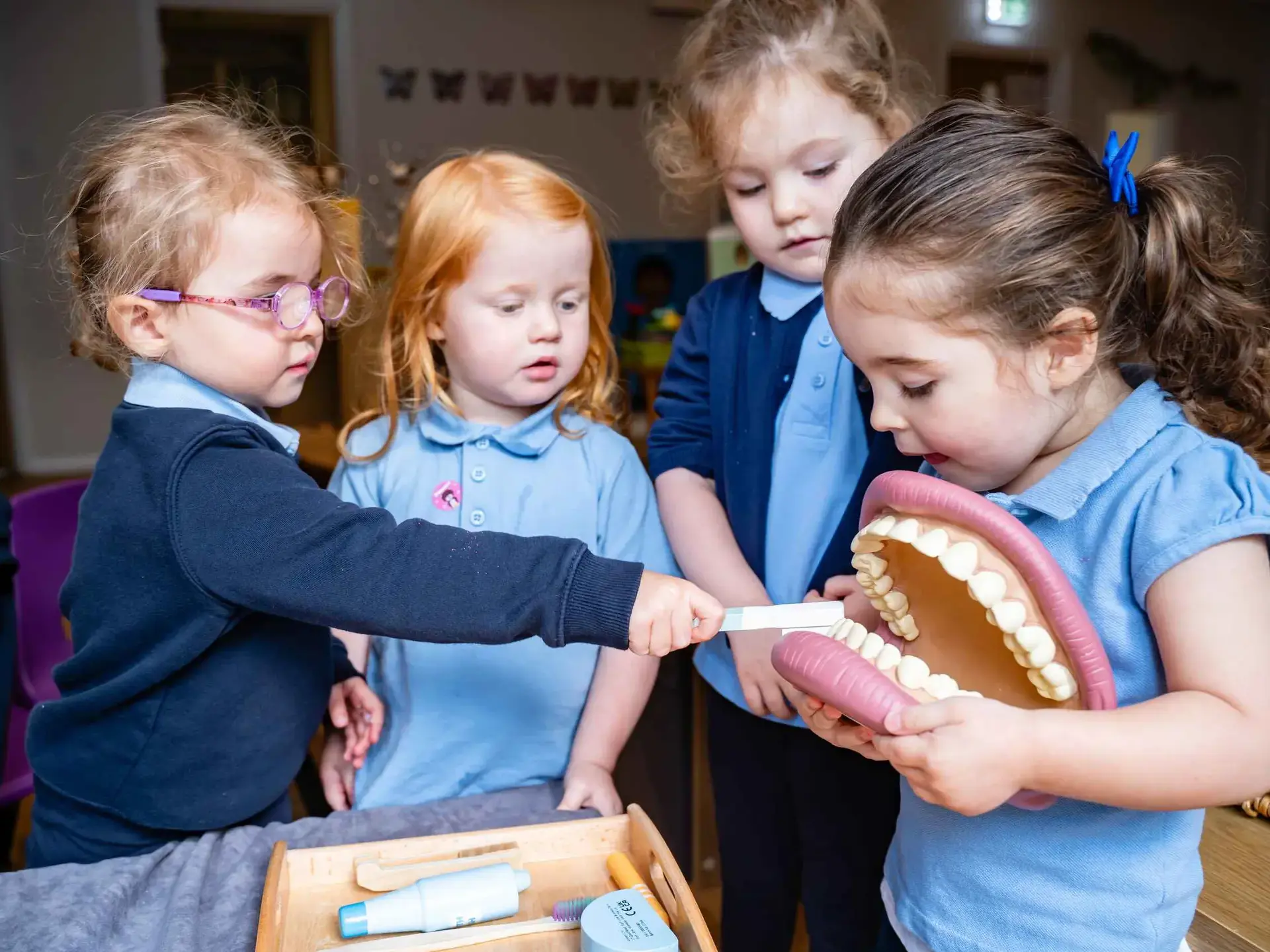 Four students looking in large dental model
