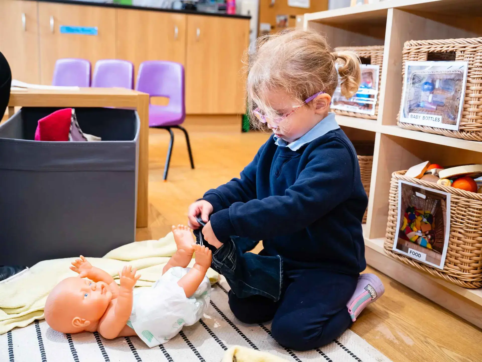 Student playing with baby doll