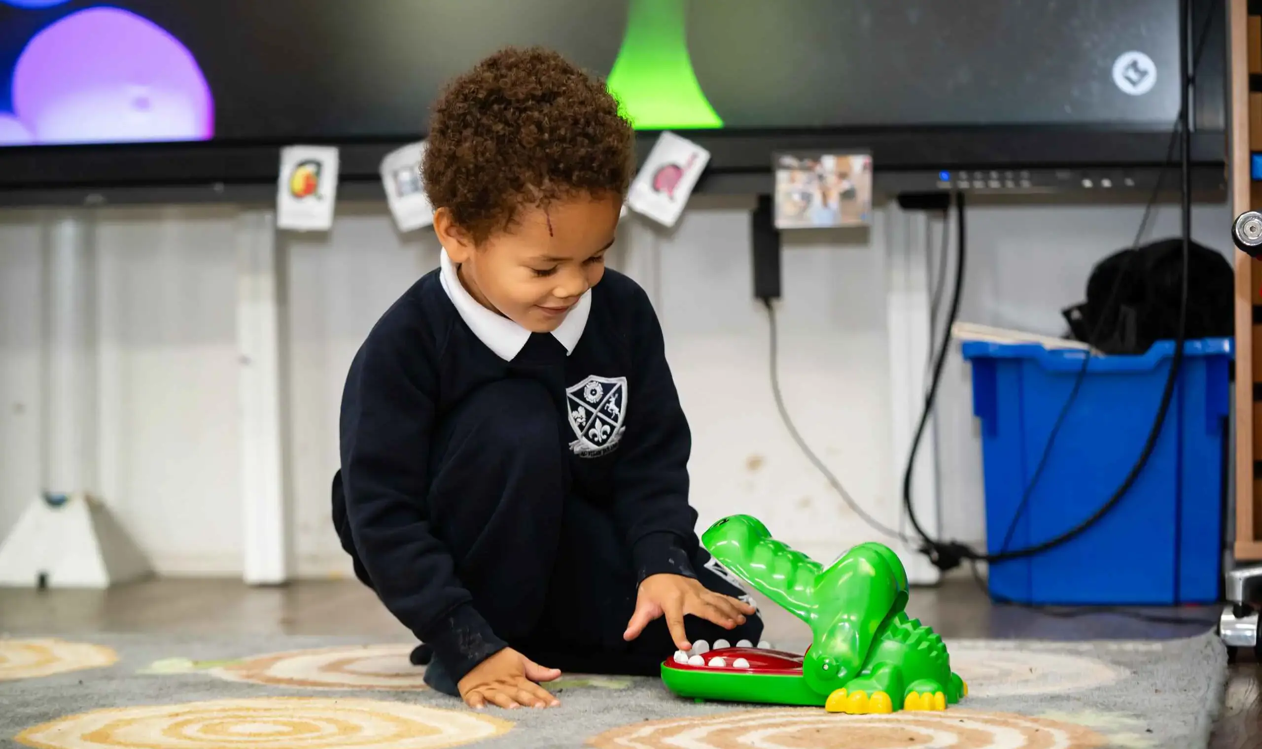 Student playing with crocodile toy