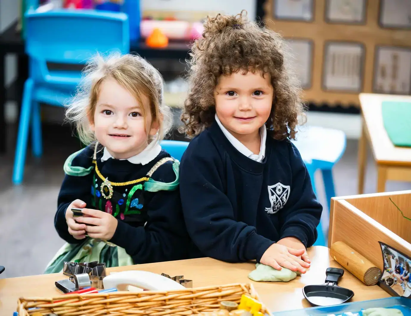 Two children smiling up from table