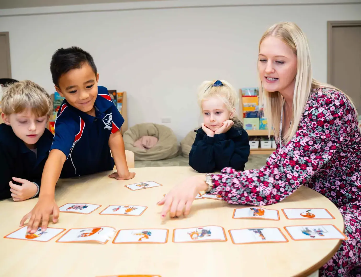 Students and teacher laying flashcards on a table