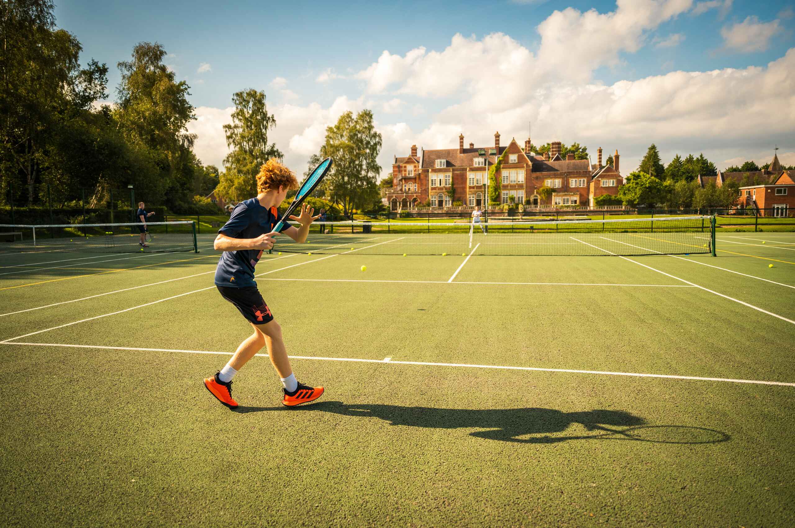 Student Playing Tennis on School Grounds