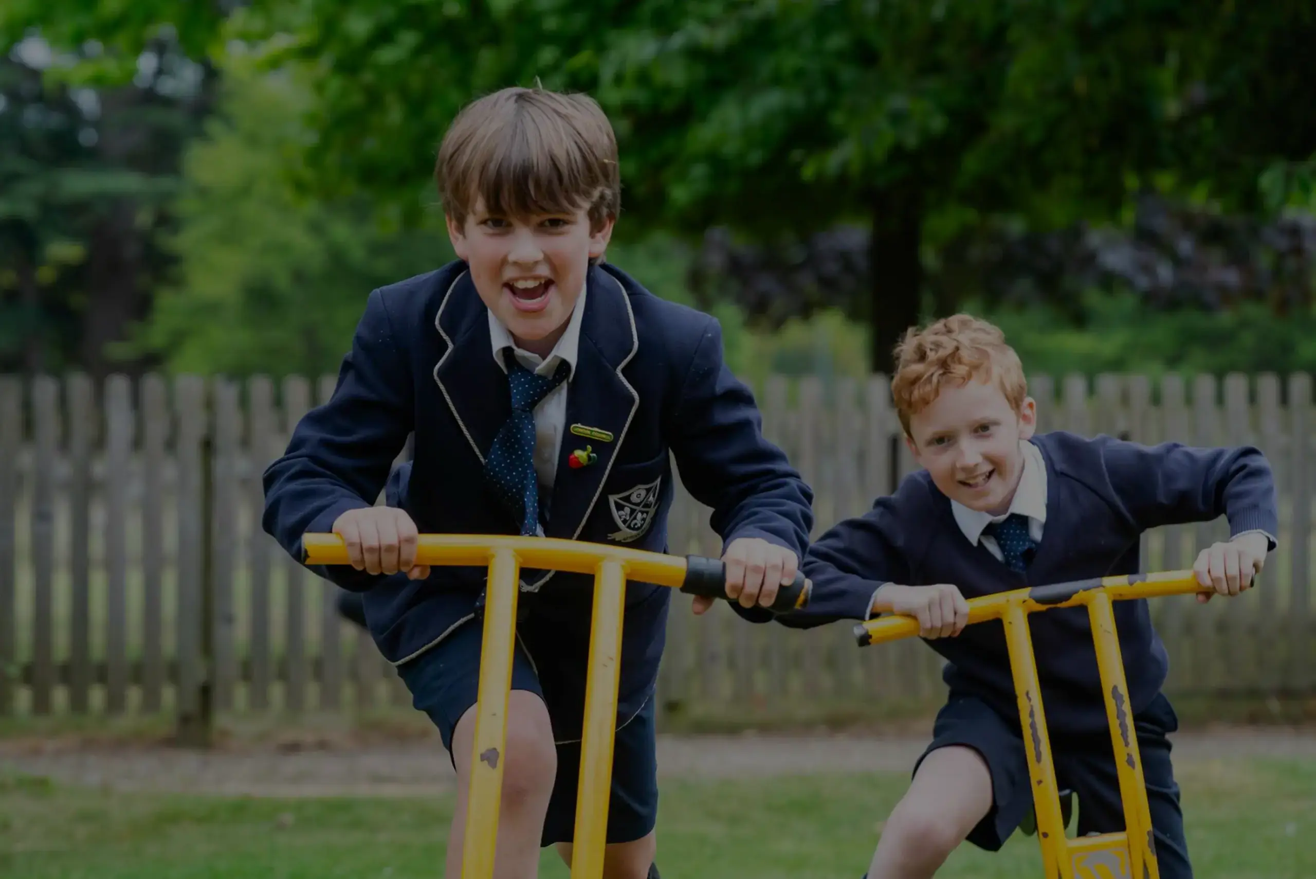 Students laughing astride playground equipment