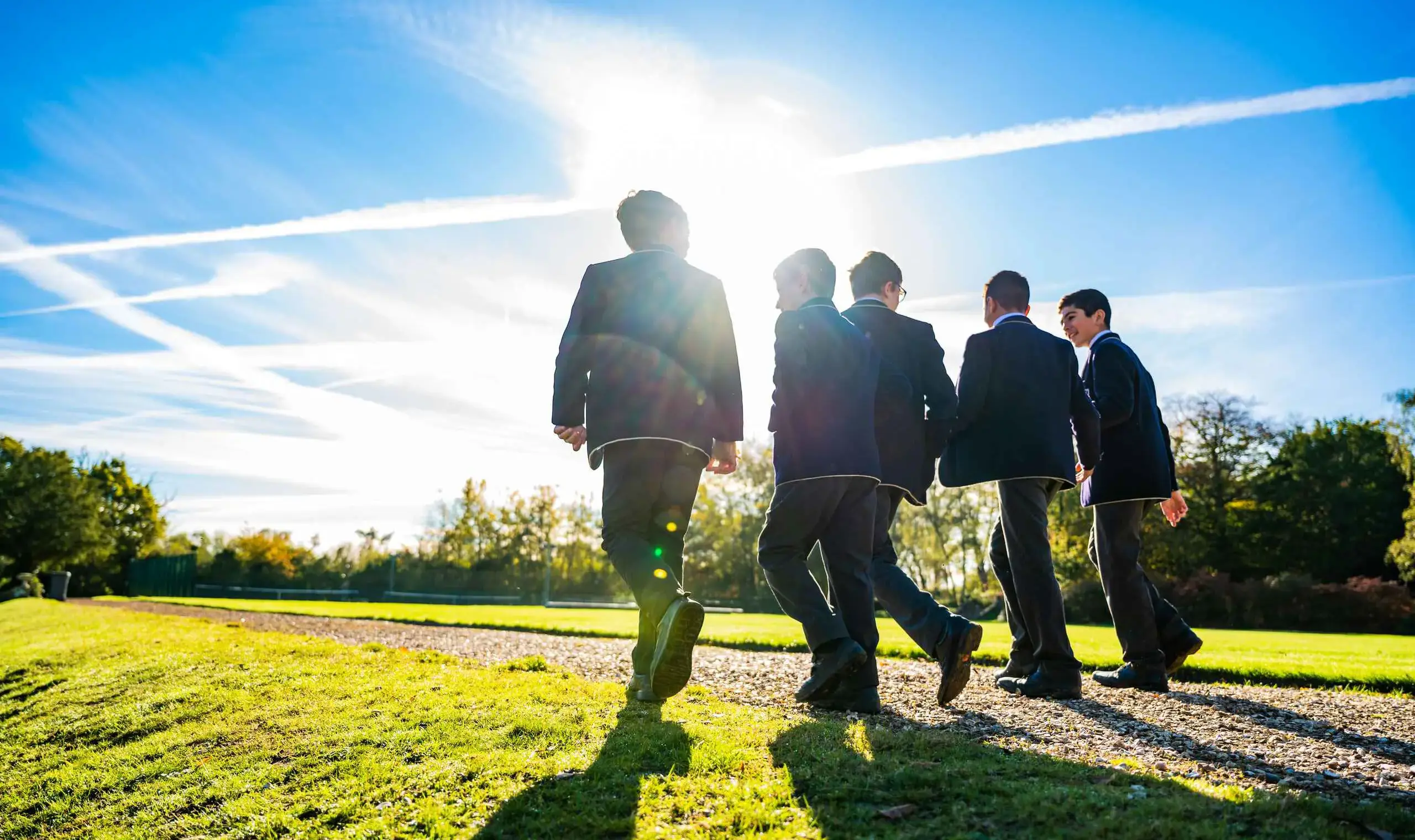 Students walking down path on sunny day