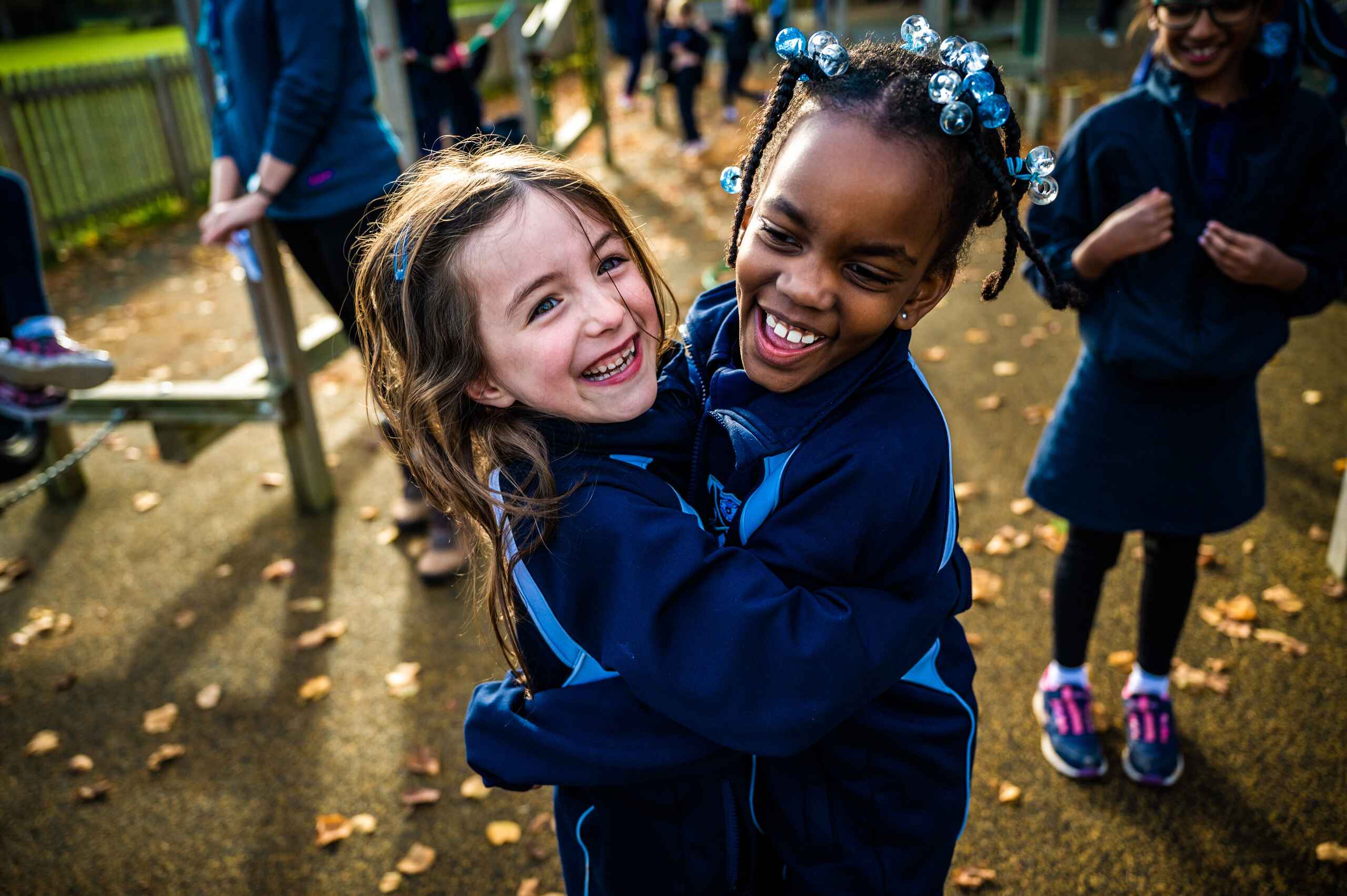 Two students hugging and laughing