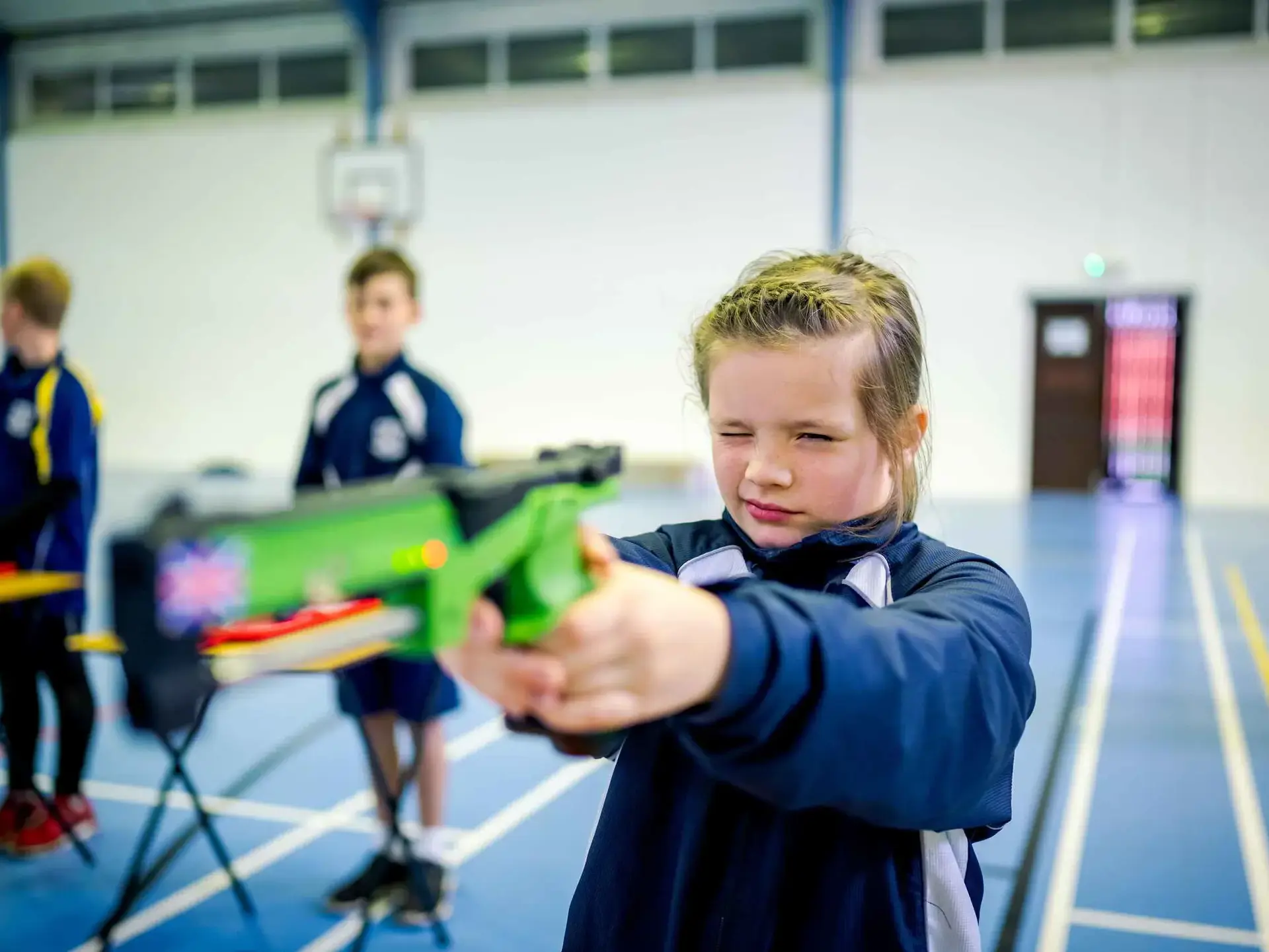 Student aiming down sights of pistol