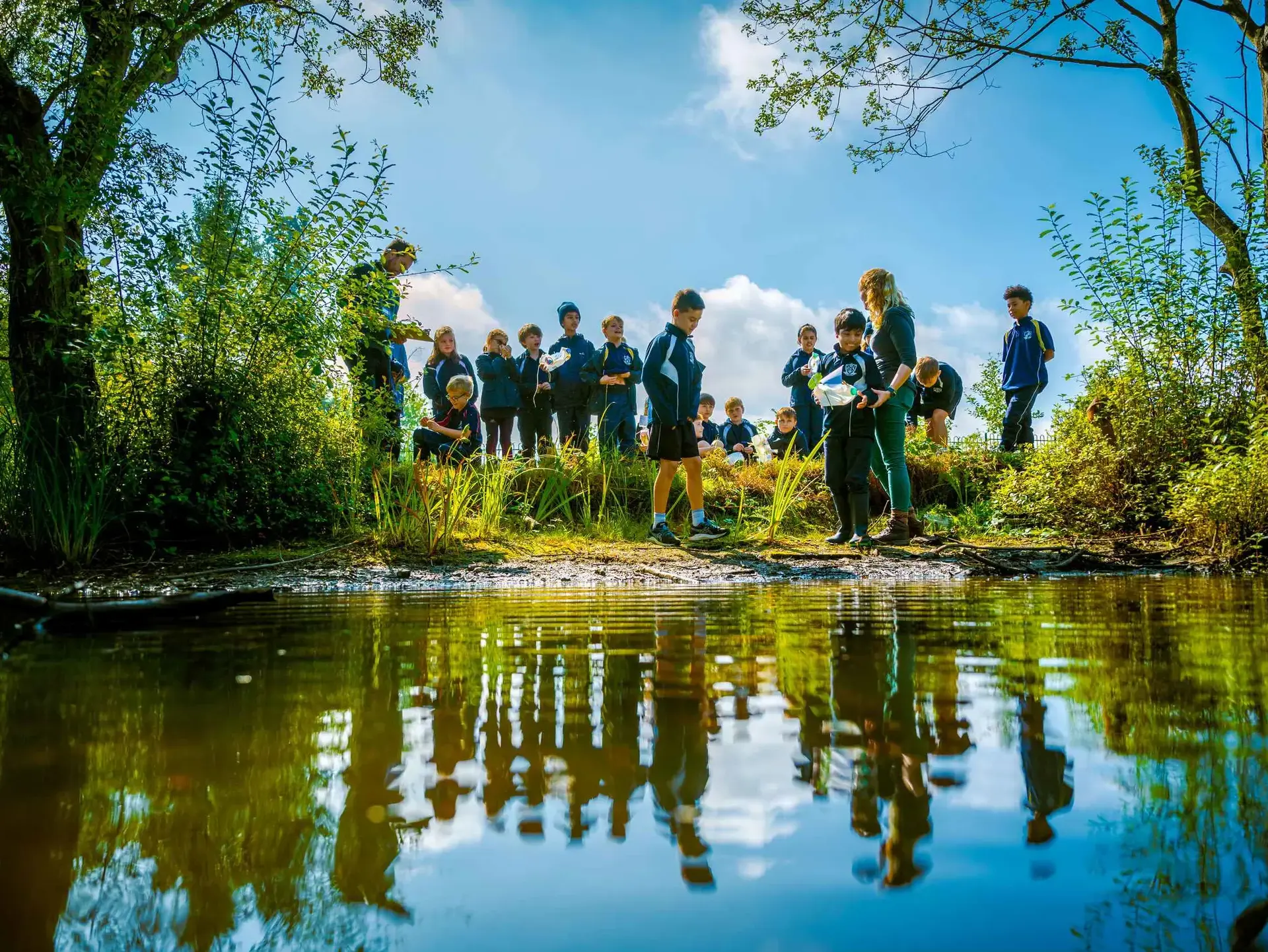 Students standing by pond