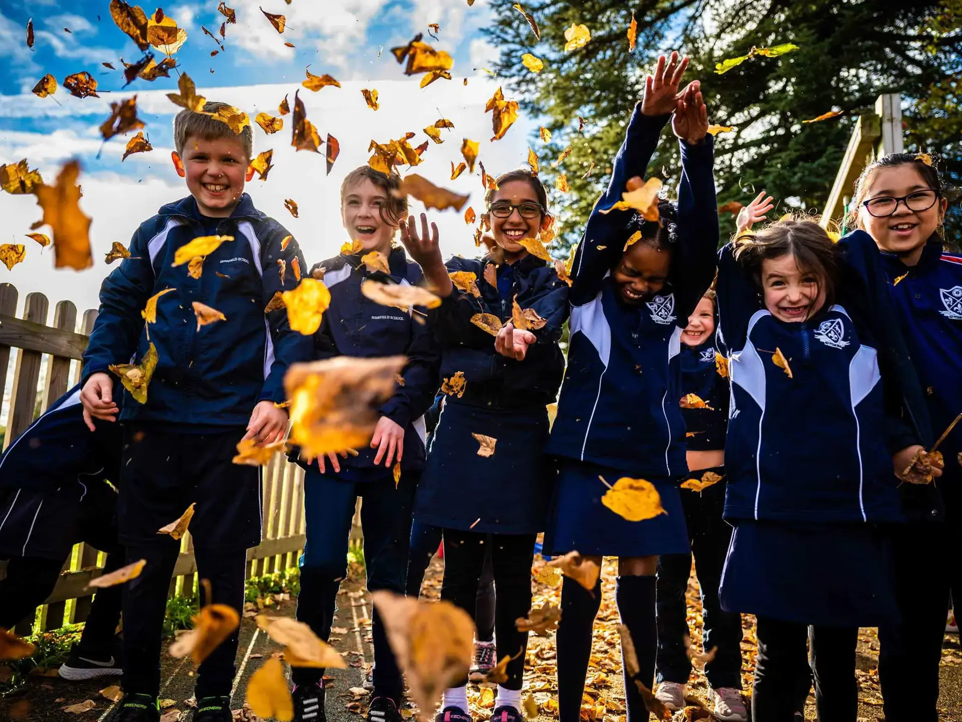 Students throwing leaves in air