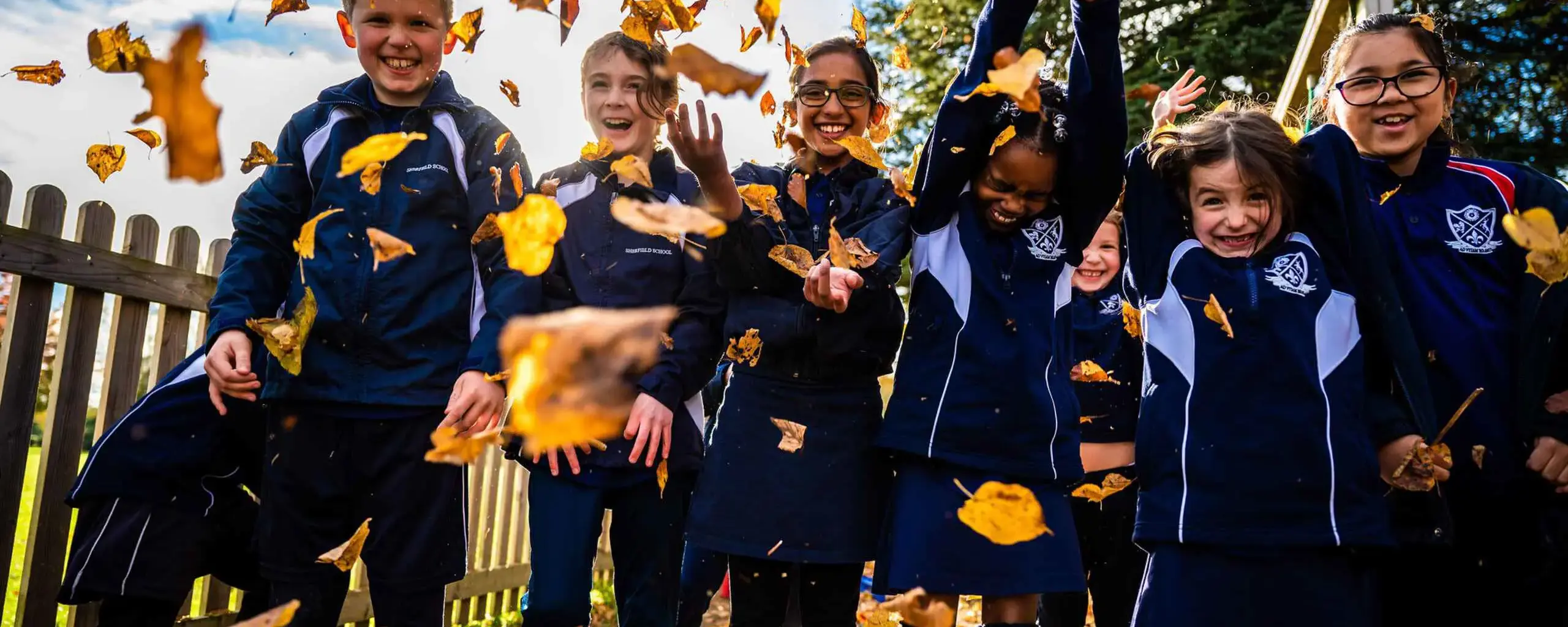 Students throwing leaves in the air