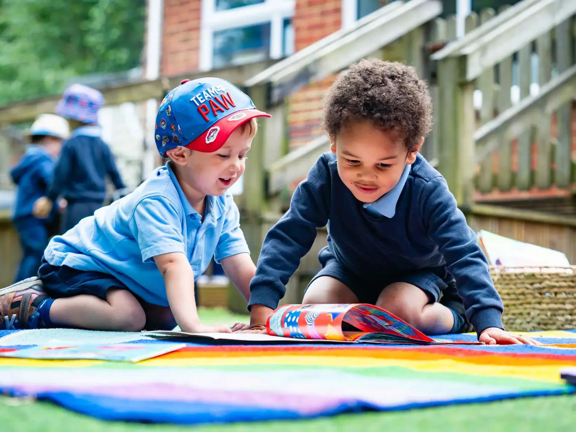 Two children reading comics outside