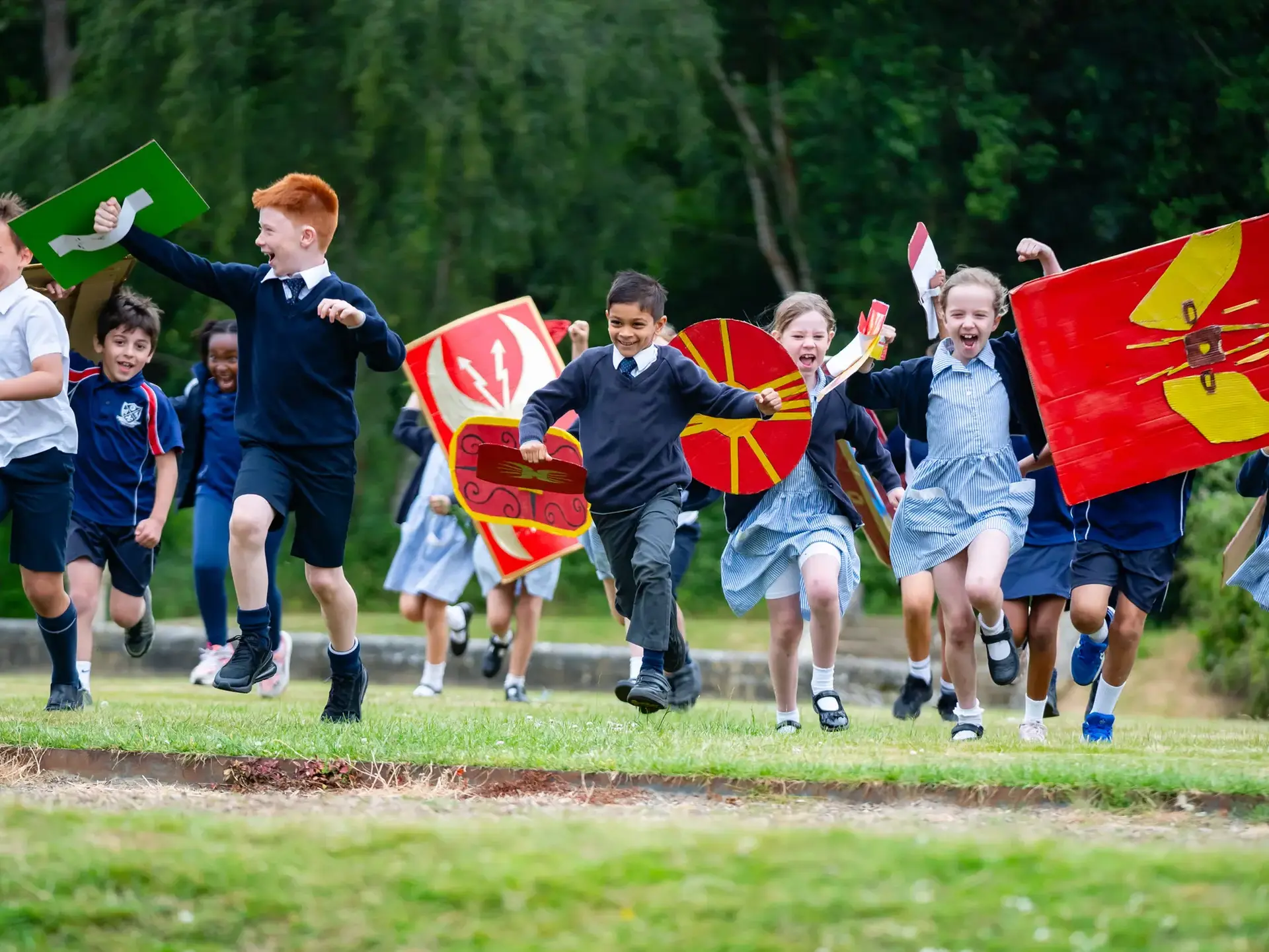 Students running across field in Roman costume