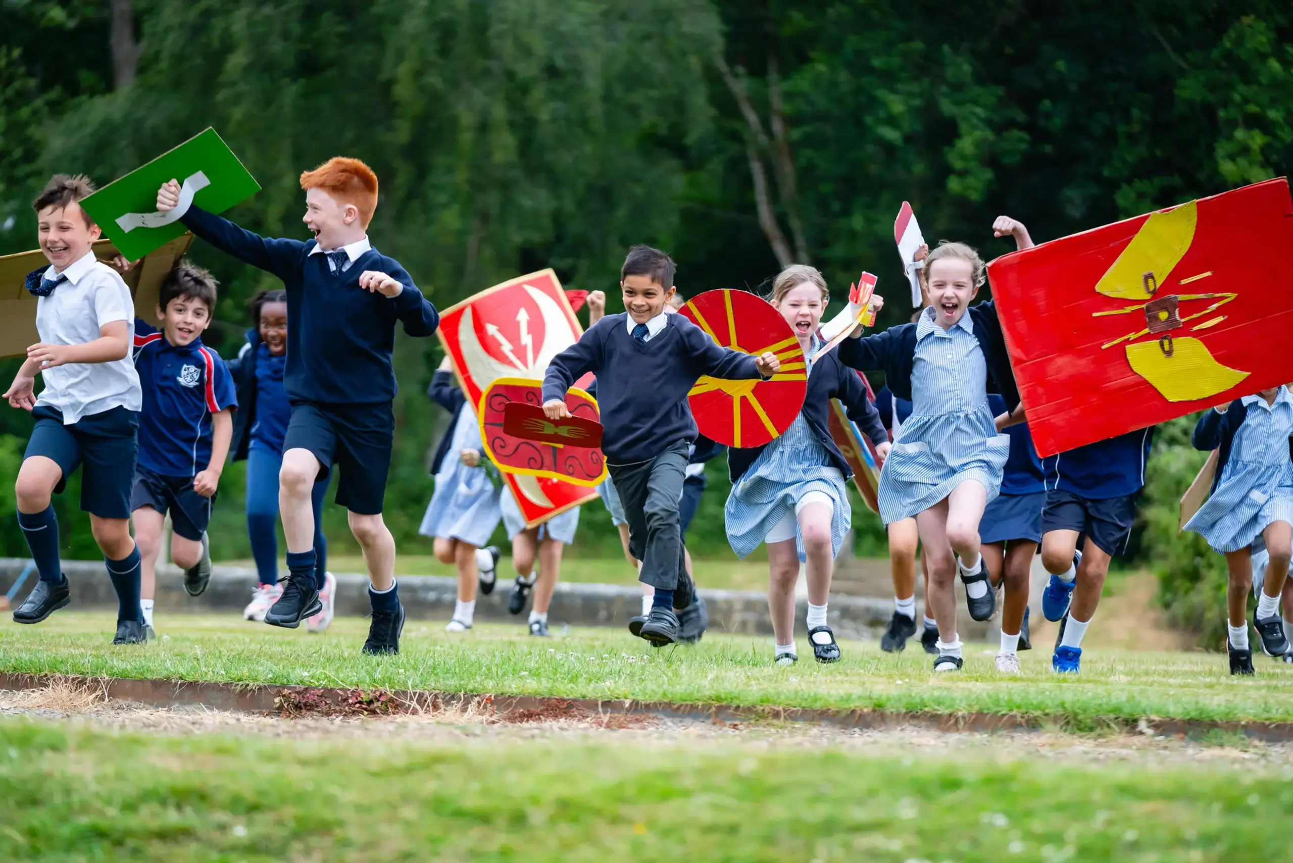 Students running across field in Roman costume
