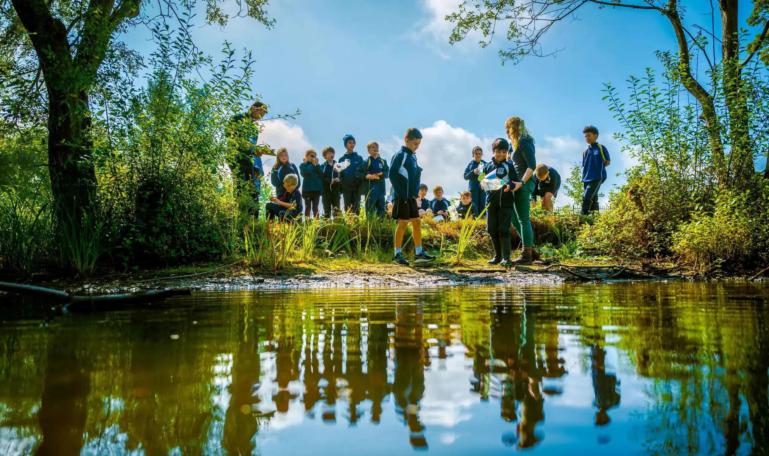 Group of students standing by pond