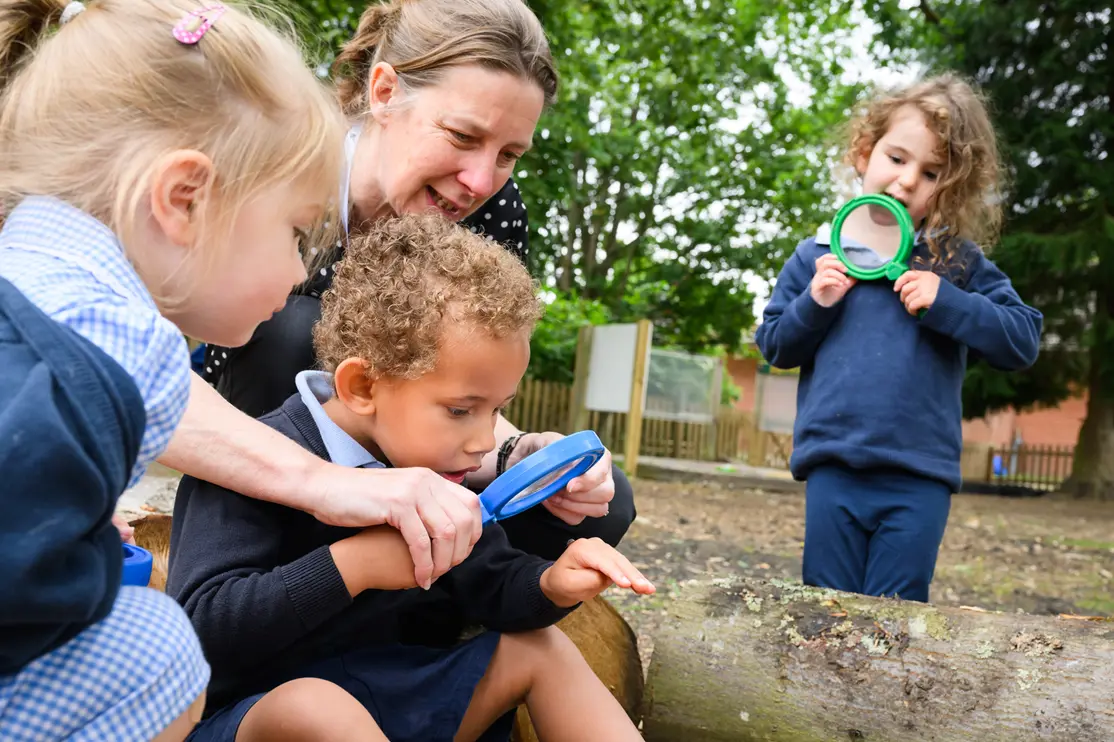 Students looking around with magnifying glasses