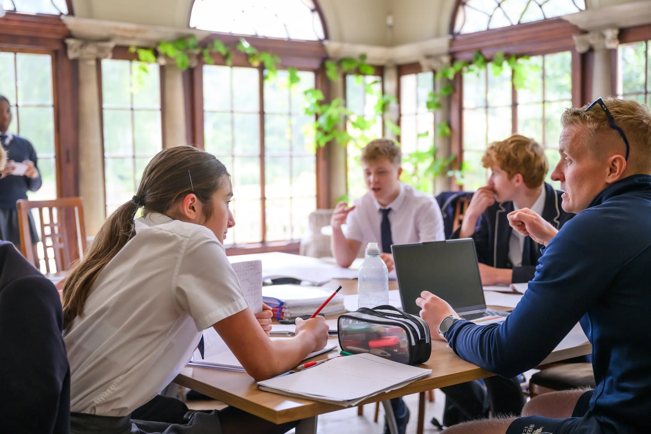 Pupils studying together in sunroom