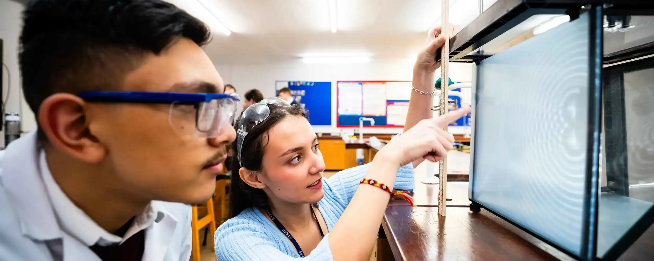 Teacher with sixth form student in physics lesson