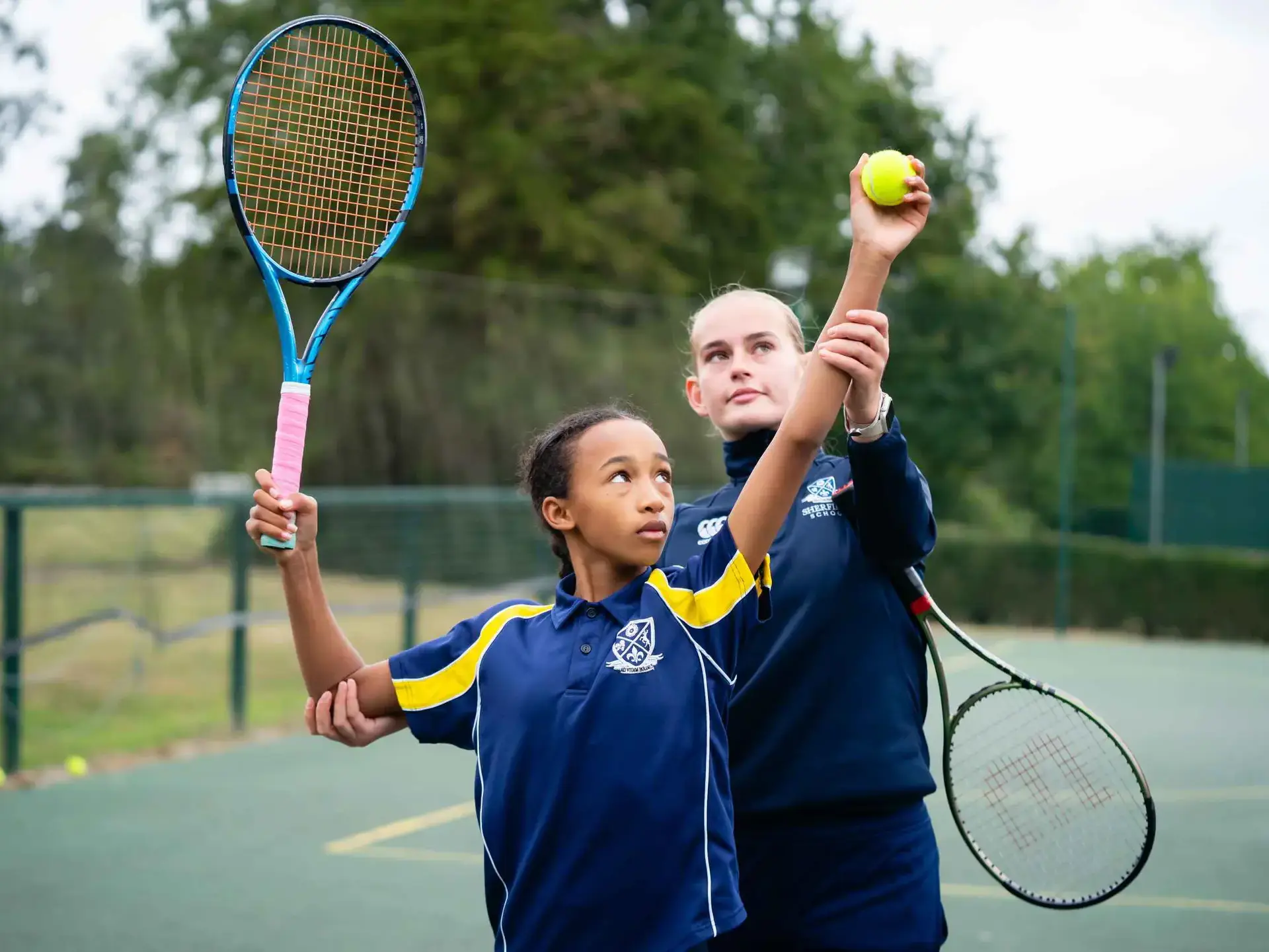 Tennis teacher and student working on serve
