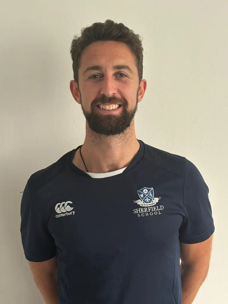 Michael Fairburn standing against a white wall